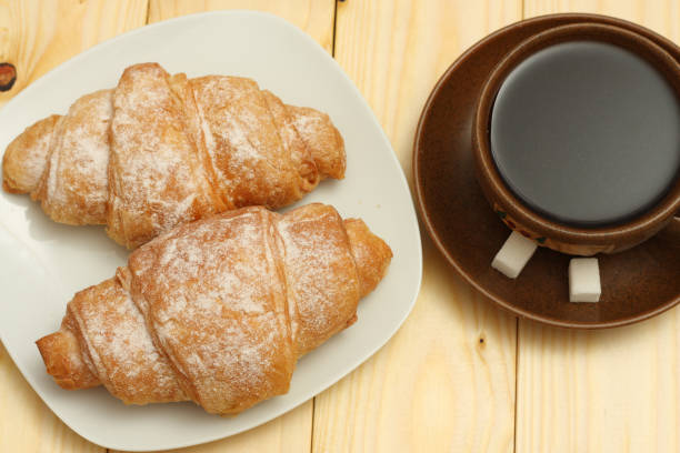 istock fresh croissant with coffee on wooden background 885606668