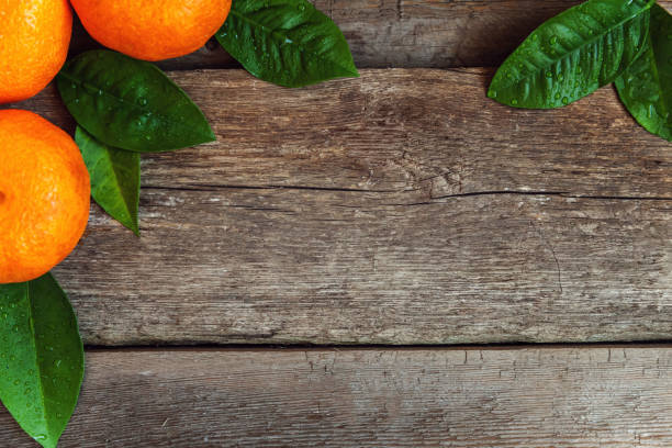 istock tangerines with leaves on wooden background 885609414