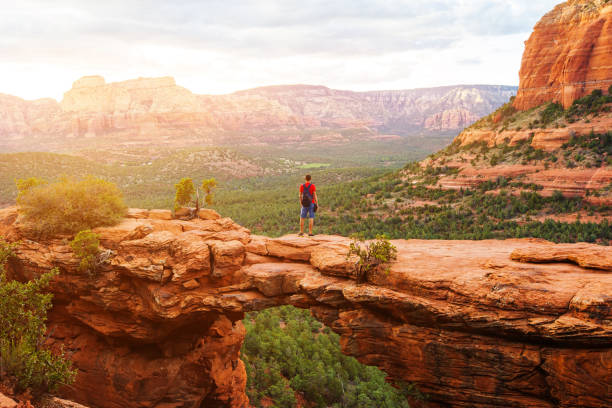 Travel in Devil's Bridge Trail, man Hiker with backpack enjoying view, Sedona, Arizona, USA Travel in Devil's Bridge Trail, man Hiker with backpack enjoying view, Sedona, Arizona, USA sedona photos stock pictures, royalty-free photos & images