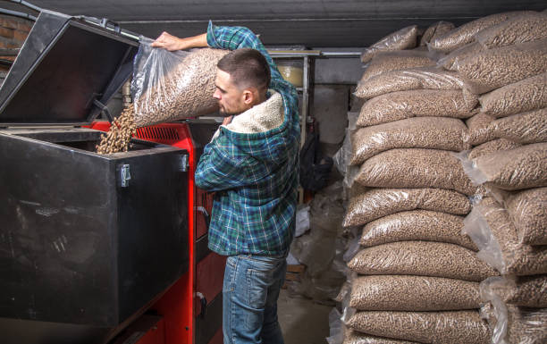 istock the man loads the pellets in the solid fuel boiler, economical heating 885667540