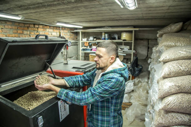 istock the man loads the pellets in the solid fuel boiler, economical heating 885667542