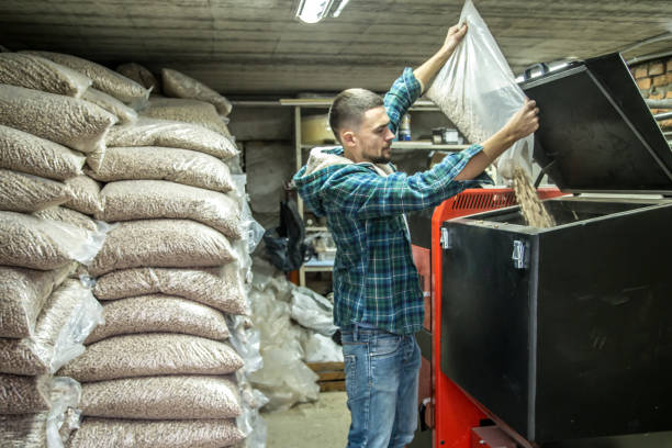 istock the man loads the pellets in the solid fuel boiler, economical heating 885667544