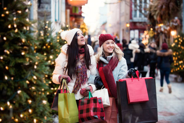shopping di natale con due giovani donne - christmas shopping foto e immagini stock