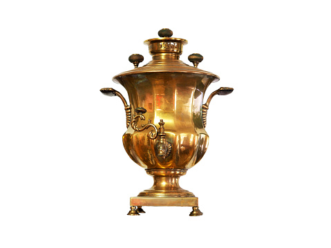 Ancient golden brass large samovar isolated on white background. Retro device for making tea with the help of wood chips, firewood and cones, an ancient Russian object