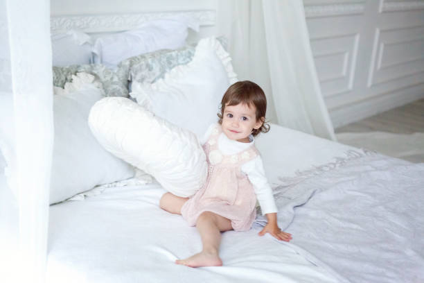 istock Cute little girl jumping on white bed 885682682