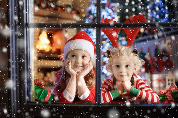 enfant au sapin de noël. enfants au foyer sur noël - christmas child baby surprise photos et images de collection