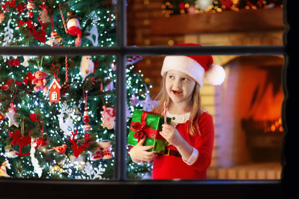 istock Child at Christmas tree and fireplace on Xmas eve 885704624