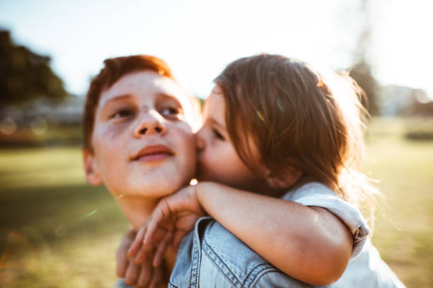 istock two lovely kids piggyback at the park 885711982