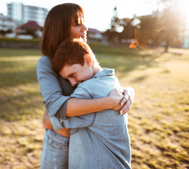 istock teenager embraced with mom consoling her son 885712082