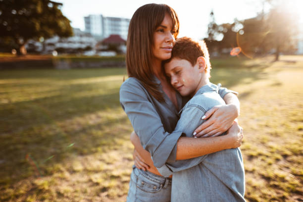 istock teenager embraced with mom consoling her son 885712128
