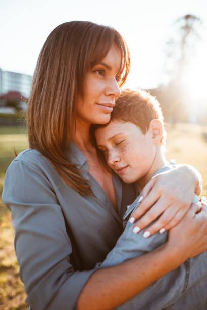 istock teenager embraced with mom consoling her son 885712340