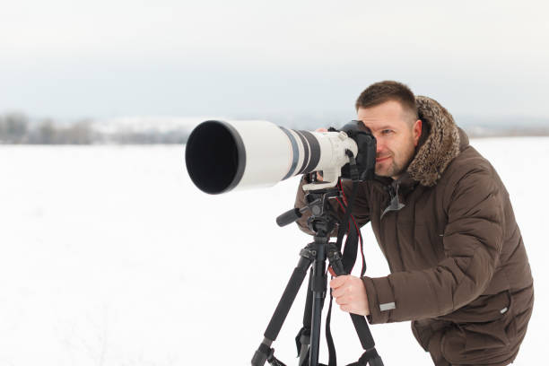 istock Man photographing using a tripod and a super telephoto lens 885719092