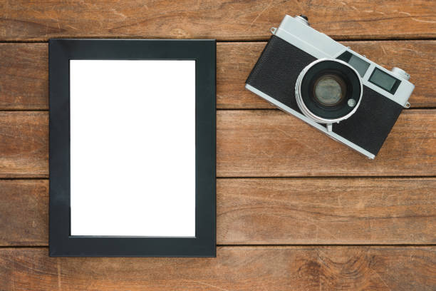 istock Office desk wooden table with old camera and poster mockup template. Top view with copy space. Top view of old camera over wooden table. Retro vintage filter. 885723246