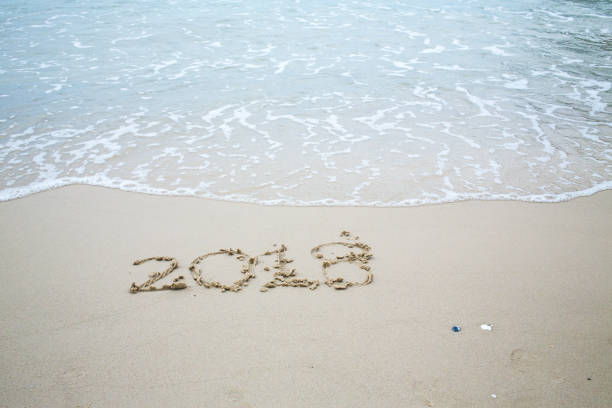 istock Happy New Year 2018, lettering on the beach, 2018 885723608
