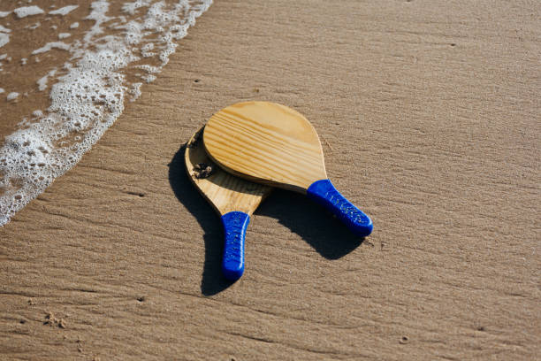 beach tennis, beach paddle ball, matkot. racchette da spiaggia e palla sulla spiaggia - matkot foto e immagini stock