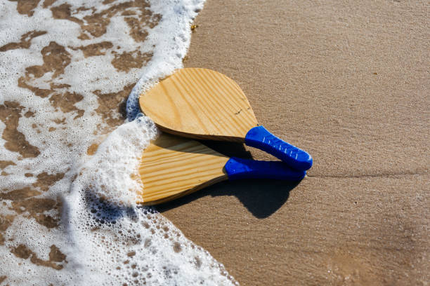 beach tennis, beach paddle ball, matkot. racchette da spiaggia e palla sulla spiaggia - matkot foto e immagini stock