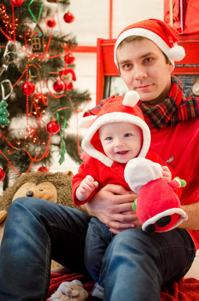 vater mit baby in der weihnachtszeit - christmas present men male people stock-fotos und bilder