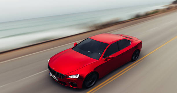 istock car driving on a road by sea 885731352