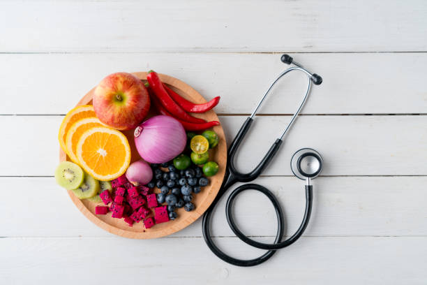 comida sana en plato de corazón con el estetoscopio del médico - diabetes food fotografías e imágenes de stock