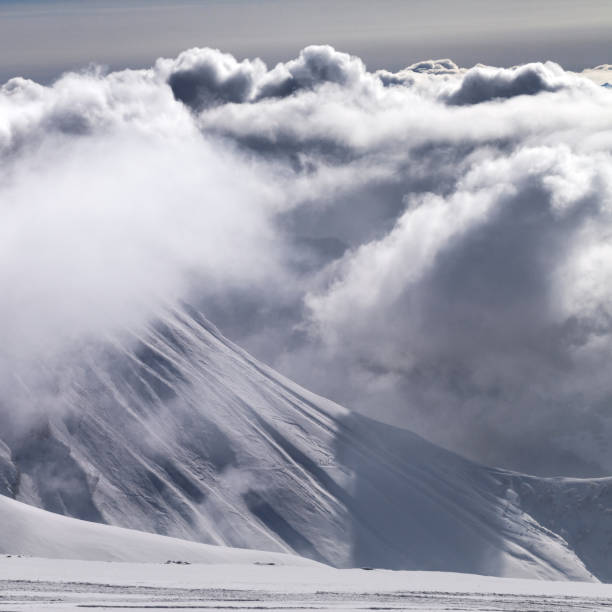istock Ski slope and mountains in sunlight storm clouds before snowfall 885734654