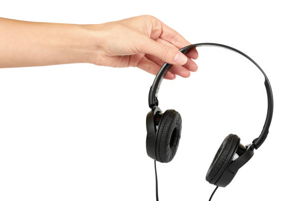 istock Black headphones in hand isolated on white background 885735462