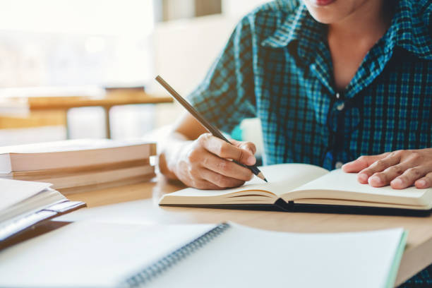 istock High school or college student studying and reading together in library 885742684