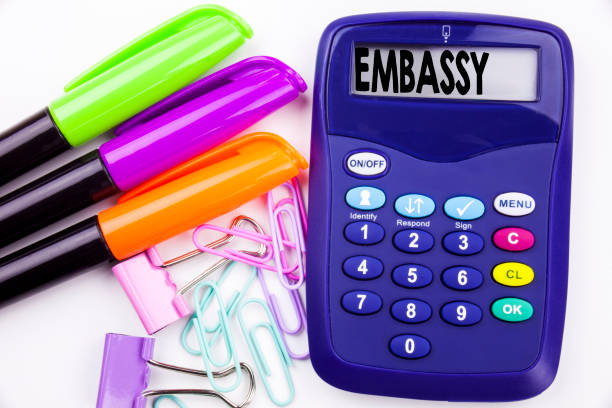 istock Writing word Embassy text in the office with surroundings such as marker, pen writing on calculator. Business concept for Tourist Visa Application white background with copy space 885749718