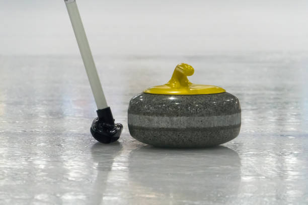 istock Brush and yellow Curling stone on the ice 885786548