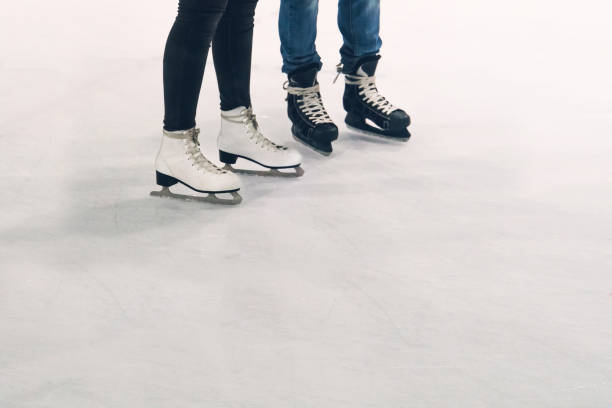 A young woman competitive figure skater training in an empty ice rink arena.