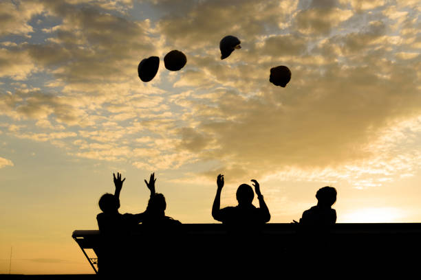 istock Silhouette of Engineers throwing up hat for celebrate after project successful in beautiful evening sky 885796750