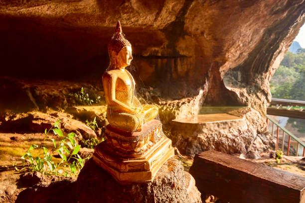 istock Golden Buddha statue in cave 885807544