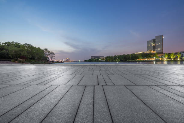 istock Empty brick floor with city skyline background at twilight 885824586