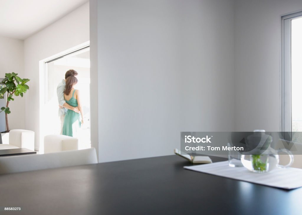 Paar umarmen im Wohnzimmer - Lizenzfrei Fenster Stock-Foto