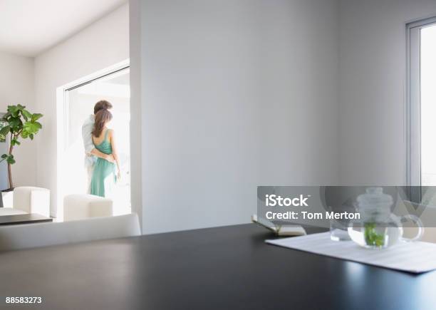 Paar Umarmen Im Wohnzimmer Stockfoto und mehr Bilder von Fenster - Fenster, Modern, Zwei Personen