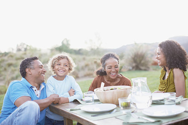 familia comiendo al aire libre - afrocaribeño fotografías e imágenes de stock