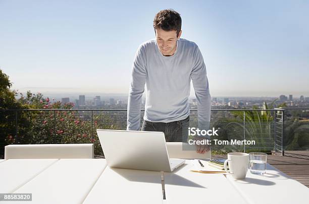 Uomo Che Lavora Da Casa Sul Balcone - Fotografie stock e altre immagini di Patio - Patio, Uomini, Balcone