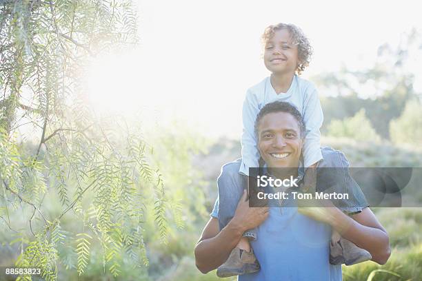 Hombre Hijo En Los Hombros De Transporte Foto de stock y más banco de imágenes de Padre - Padre, Aire libre, Hijo