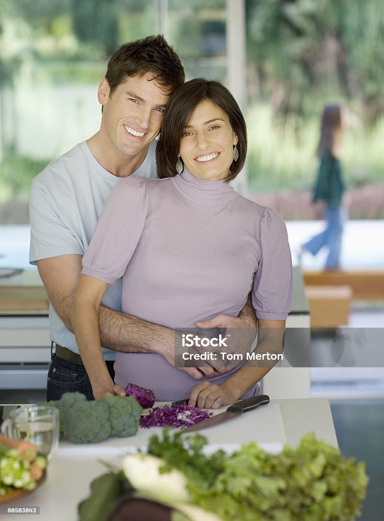 Pareja abrazándose en la cocina - Foto de stock de 30-34 años libre de derechos