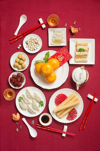 Flat lay Chinese new year reunion dinner food and drink still life. Texts appear in image: Prosperity, spring, good luck.