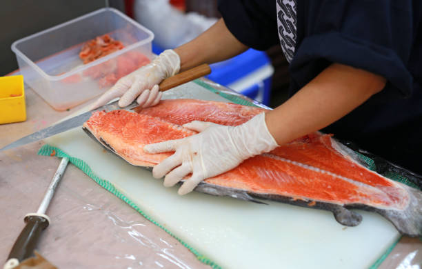 istock Chef slicing raw fish for salmon sushi on a cutting board. 885855954