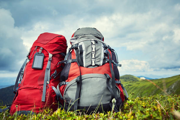 istock Backpacks in the mountains overlooking the mountains on the green grass. 885892126