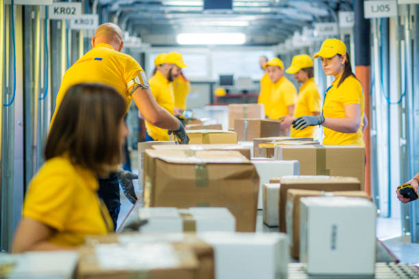 istock Delivery warehouse workers handling packages on conveyor belt 885900134