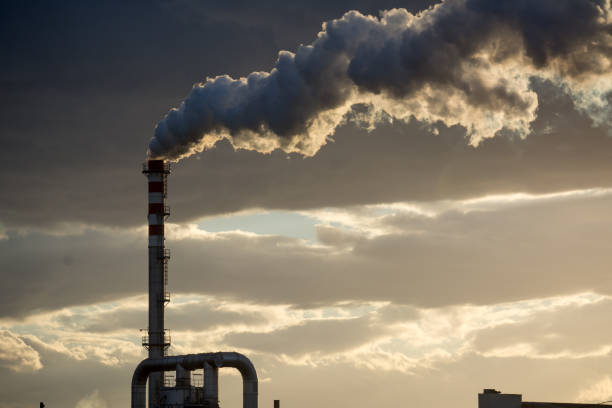 istock Smoking Red and White Bands Chimney On Backlight With White Smoke 885907952