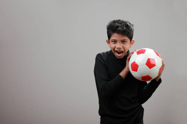 istock Cheerful boy holds a soccer ball in his hand 885920172