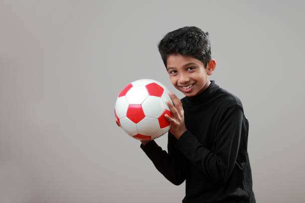 istock Cheerful boy holds a soccer ball in his hand 885920284