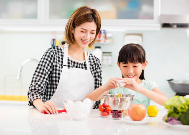 istock Happy mother and child in kitchen preparing cookies 885928968
