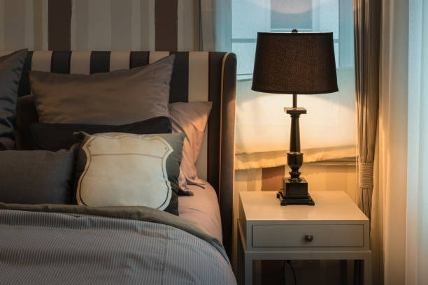 istock cozy bedroom interior with dark brown pillows and reading lamp on bedside table 885928988