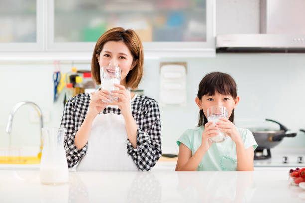 istock Happy mother and child in kitchen drinking milk 885929012