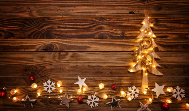 istock Christmas background with wooden decorations, tree and spot ligh 885939616