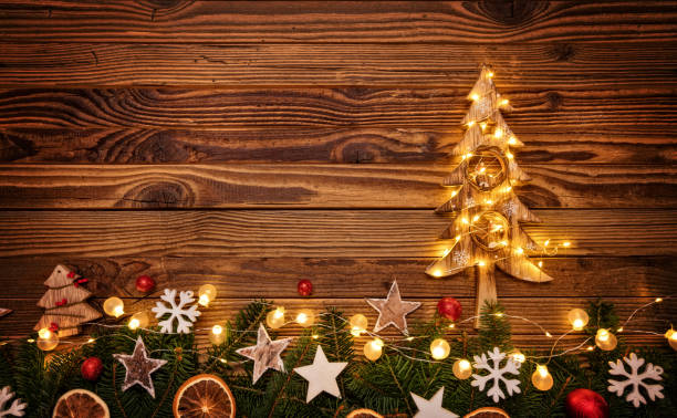 istock Christmas background with wooden decorations, tree and spot ligh 885941676